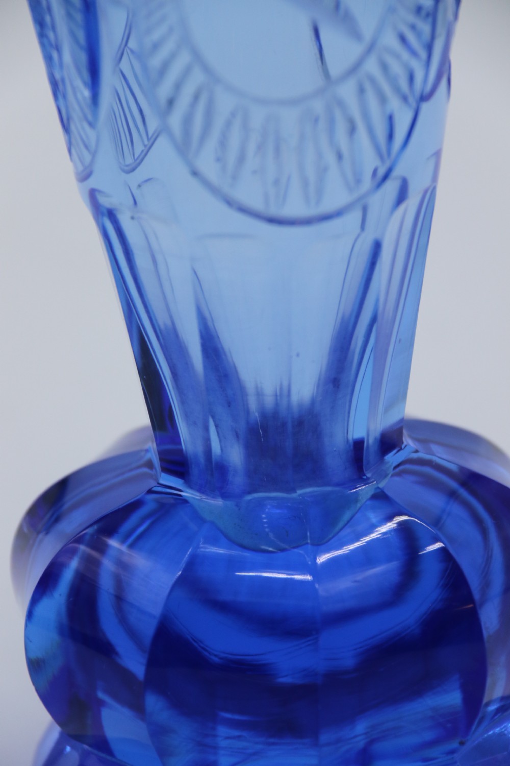 A flared Art Deco sapphire blue cut glass vase featuring geometric carved details on a faceted bulbous pedestal base. View XIV