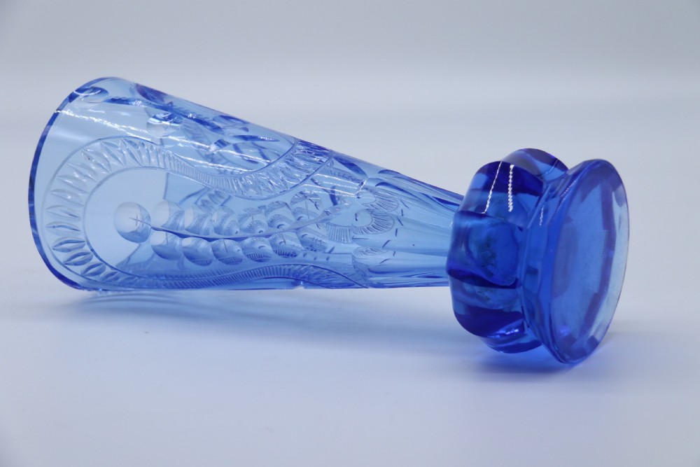 A flared Art Deco sapphire blue cut glass vase featuring geometric carved details on a faceted bulbous pedestal base. View XVIII