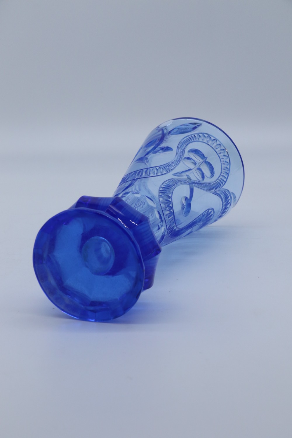 A flared Art Deco sapphire blue cut glass vase featuring geometric carved details on a faceted bulbous pedestal base. View XIX