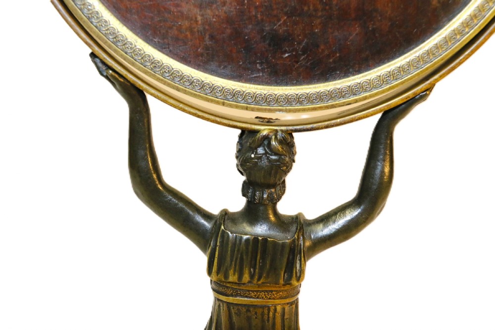 A French Empire period pedestal mirror featuring a patinated bronze classical female caryatid holding a circular tilting mirror with a gilt bronze bezel and base. View XV