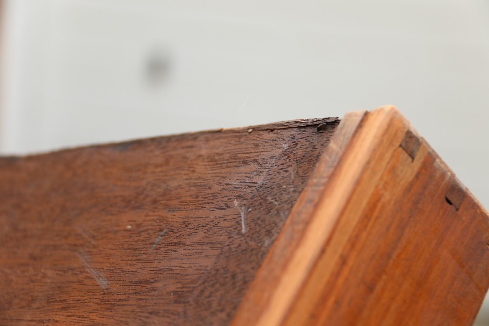 An early 19th-century flame mahogany library table featuring floral marquetry top borders, two frieze drawers with brass knobs, and carved trestle legs connected by a turned stretcher. View XXVI