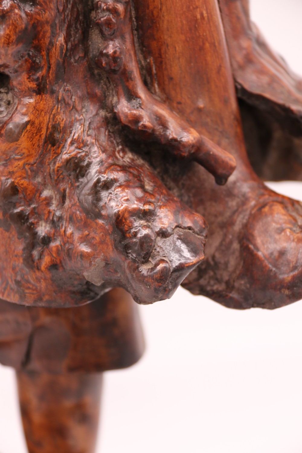 A late 19th-century Chinese carved burr root wood figure depicting a bearded scholar holding a staff, set upon a carved wood base. View XV