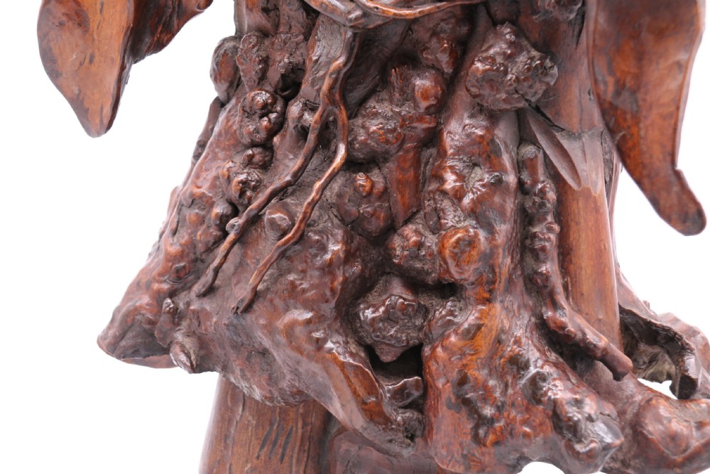 A late 19th-century Chinese carved burr root wood figure depicting a bearded scholar holding a staff, set upon a carved wood base. View XXVIII