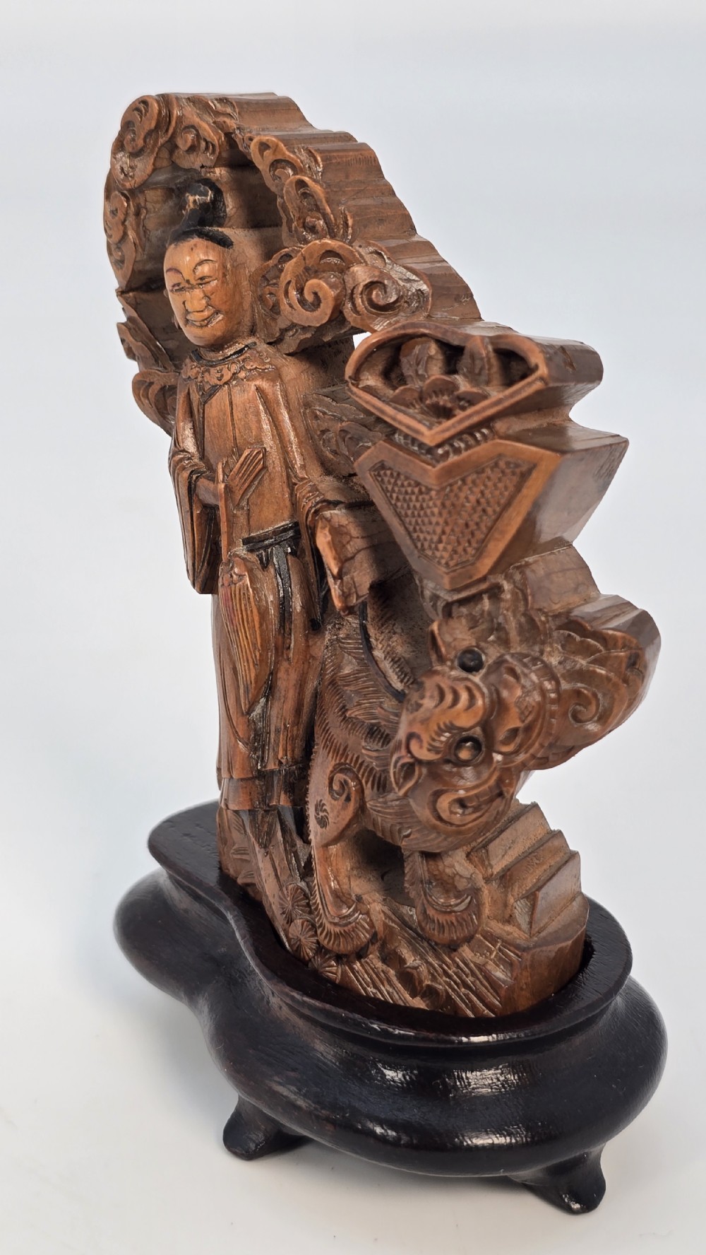 A Japanese carved bamboo okimono figure depicted beside a mythological beast on a dark carved hardwood base. View XIV