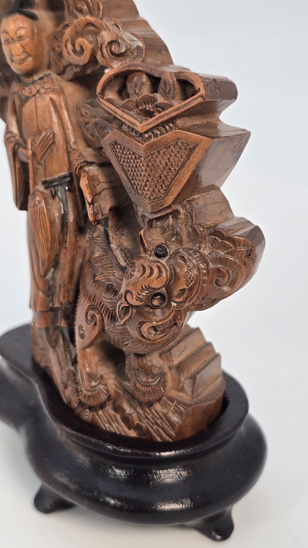 A Japanese carved bamboo okimono figure depicted beside a mythological beast on a dark carved hardwood base. View XV