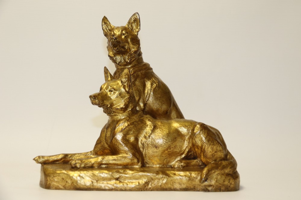 A French gilt bronze sculpture depicting two German Shepherd dogs on a naturalistic integrated base, one resting lying down and one sitting upright behind. View V
