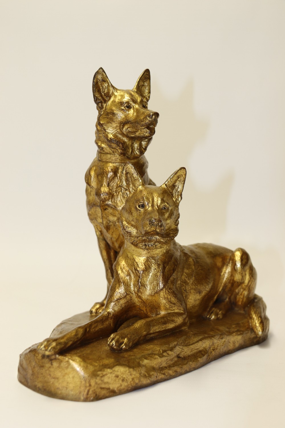 A French gilt bronze sculpture depicting two German Shepherd dogs on a naturalistic integrated base, one resting lying down and one sitting upright behind. View VI