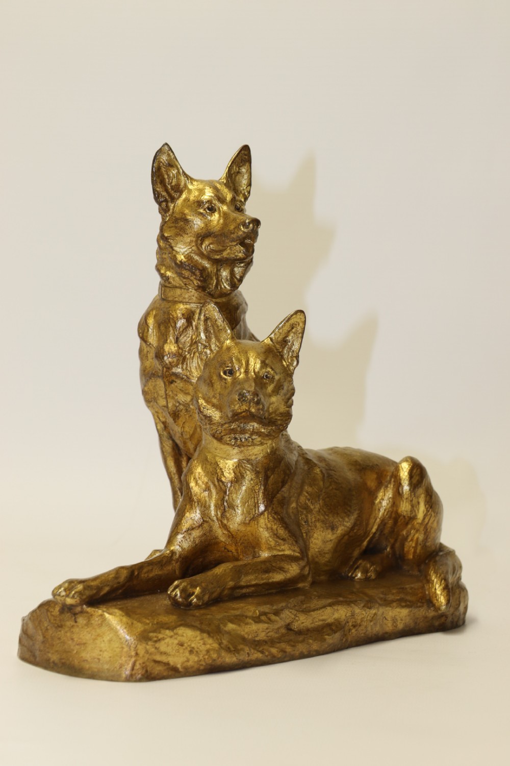 A French gilt bronze sculpture depicting two German Shepherd dogs on a naturalistic integrated base, one resting lying down and one sitting upright behind. View VIII