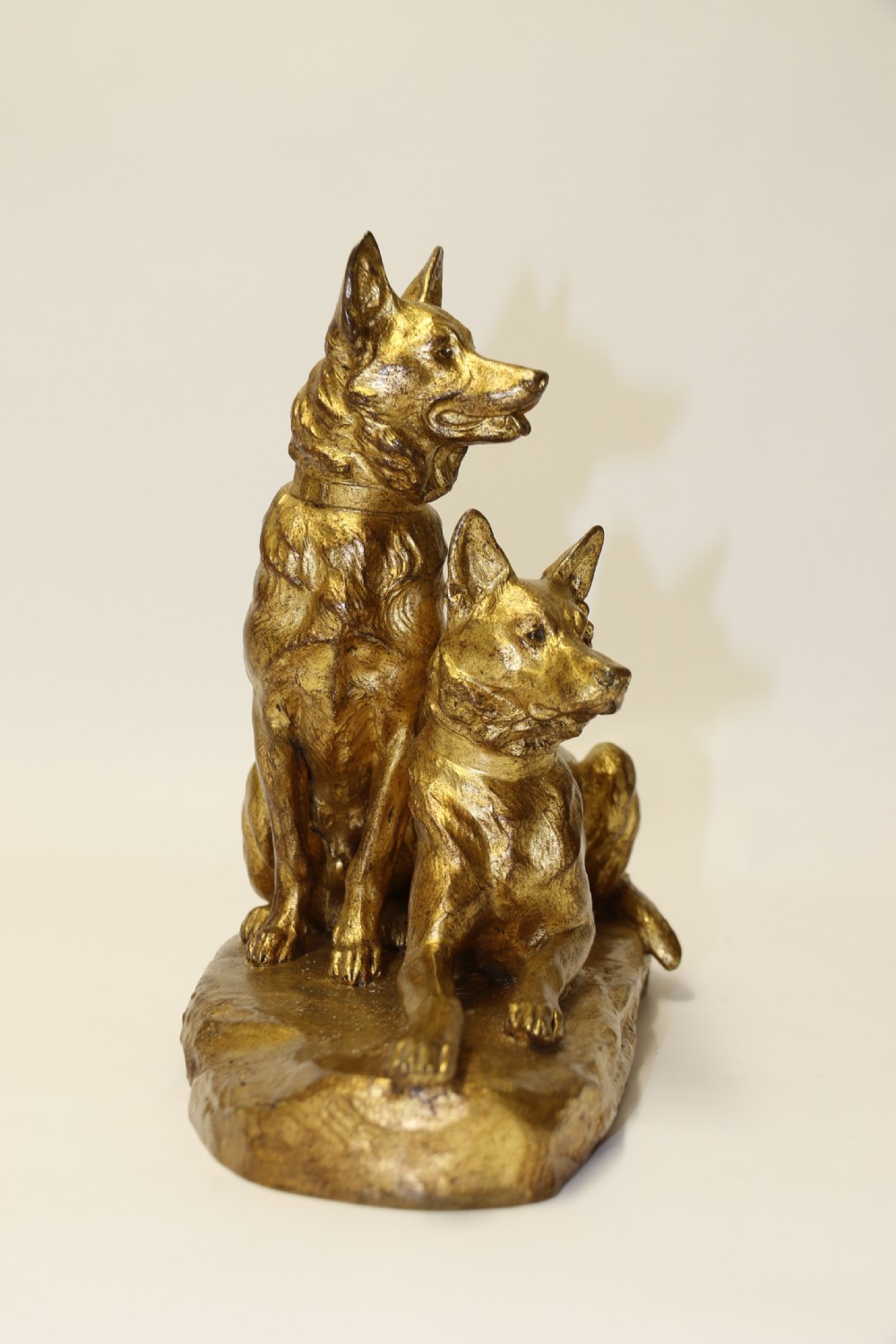 A French gilt bronze sculpture depicting two German Shepherd dogs on a naturalistic integrated base, one resting lying down and one sitting upright behind. View IX