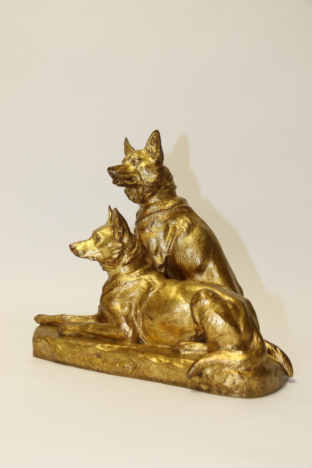 A French gilt bronze sculpture depicting two German Shepherd dogs on a naturalistic integrated base, one resting lying down and one sitting upright behind. View X