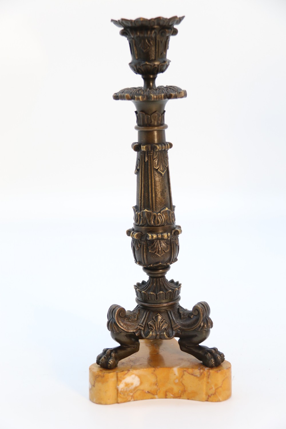 A pair of antique French Empire dark bronze candlesticks with ornate floral carvings and claw feet, resting upon yellow sienna marble plinths. View XIII
