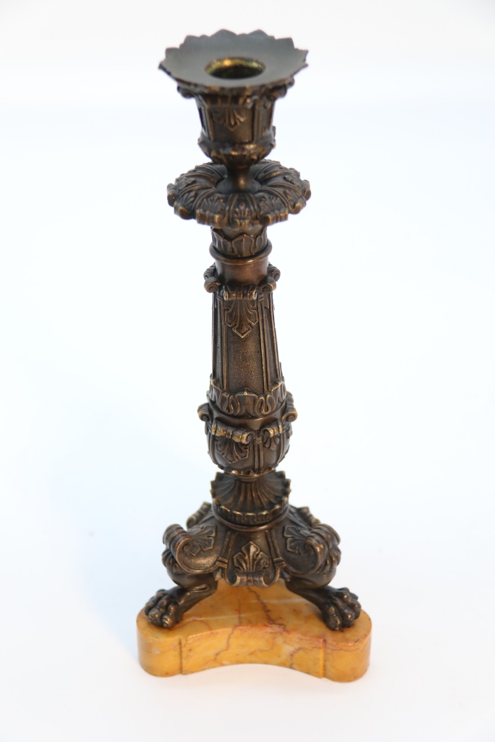 A pair of antique French Empire dark bronze candlesticks with ornate floral carvings and claw feet, resting upon yellow sienna marble plinths. View XVIII