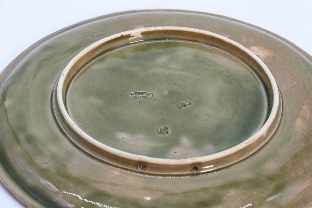 A circular late nineteenth-century Austrian majolica decorative plate featuring relief mouldings of birds perched on branches beside sunflowers over a teal glazed background. View XV