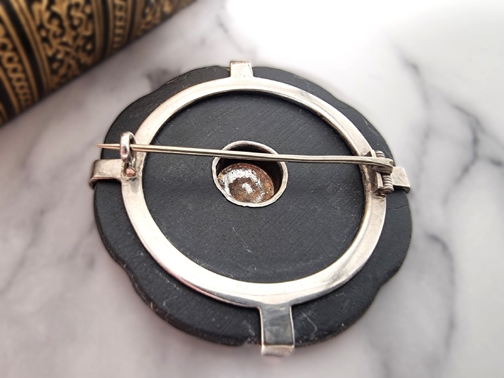 A late 19th-century circular Scottish silver brooch featuring segmented wedge inlays of varied banded agates and jaspers surrounding a central silver disc. View III