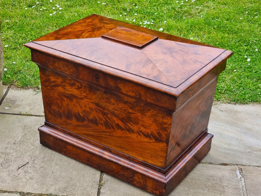 A Regency period sarcophagus-shaped wine cooler crafted from flame mahogany veneer with a stepped pediment lid and plinth base. View III