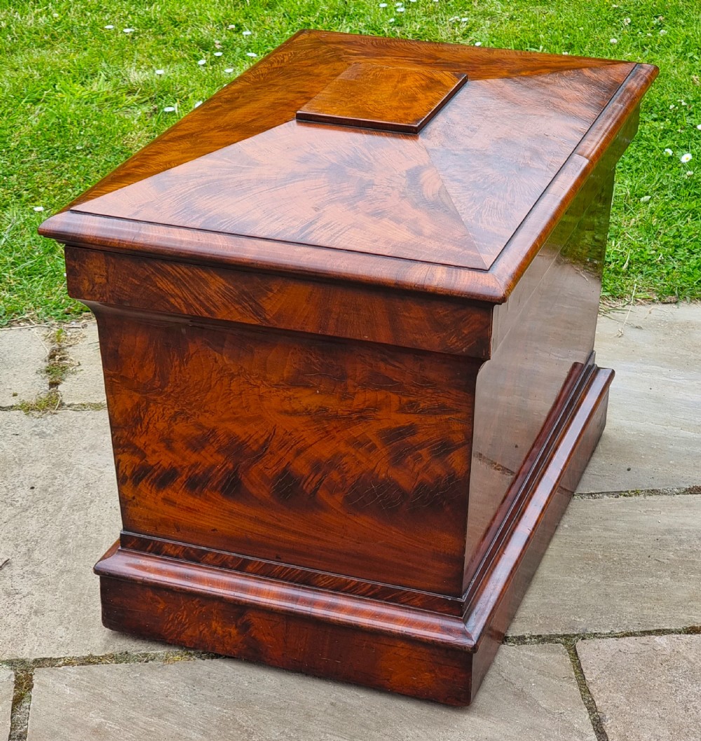 A Regency period sarcophagus-shaped wine cooler crafted from flame mahogany veneer with a stepped pediment lid and plinth base. View IV