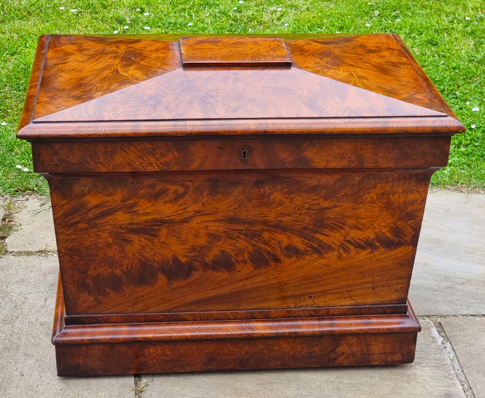 A Regency period sarcophagus-shaped wine cooler crafted from flame mahogany veneer with a stepped pediment lid and plinth base. View VIII