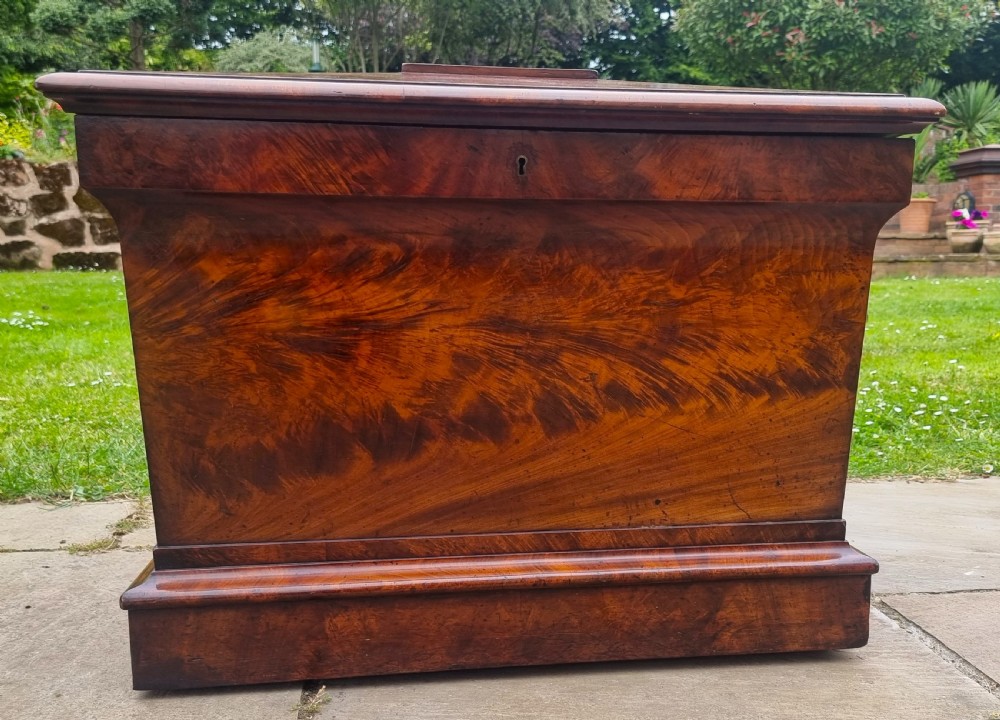 A Regency period sarcophagus-shaped wine cooler crafted from flame mahogany veneer with a stepped pediment lid and plinth base. View XV