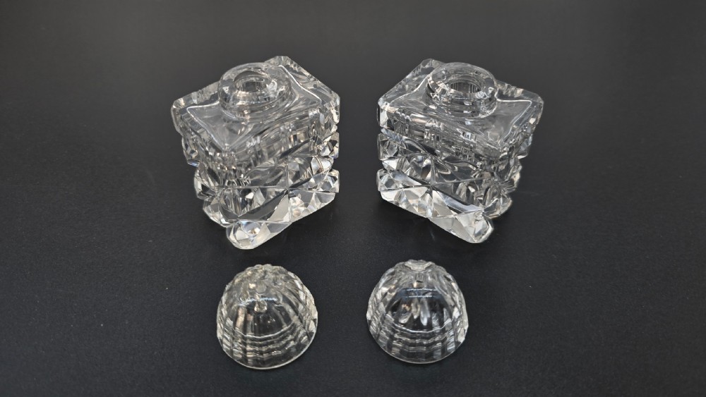 An Art Deco cut lead crystal five-piece cruet set featuring two stoppered bottles and two lidded pots arranged on an integral geometric glass tray. View VI