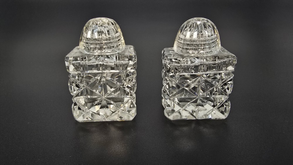 An Art Deco cut lead crystal five-piece cruet set featuring two stoppered bottles and two lidded pots arranged on an integral geometric glass tray. View XIII