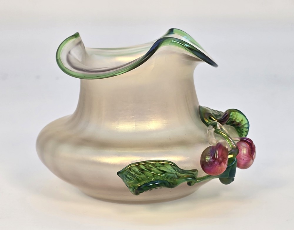 An Art Nouveau iridescent glass vase featuring a wavy green-rimmed mouth and hand-applied glass cherries with green leaves on the side. View IX