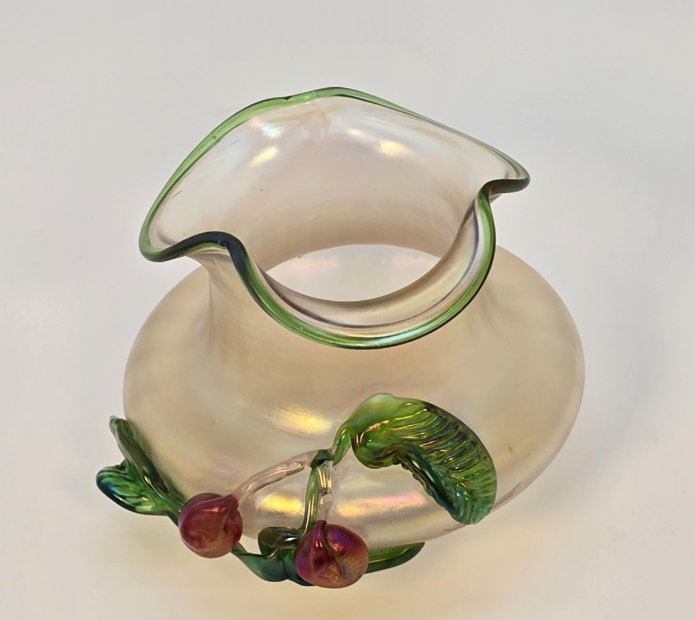 An Art Nouveau iridescent glass vase featuring a wavy green-rimmed mouth and hand-applied glass cherries with green leaves on the side. View XI