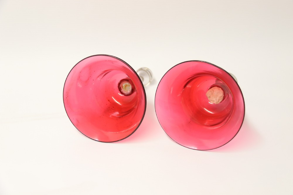A pair of Victorian hand bells crafted from ruby red glass with clear glass baluster handles. View V