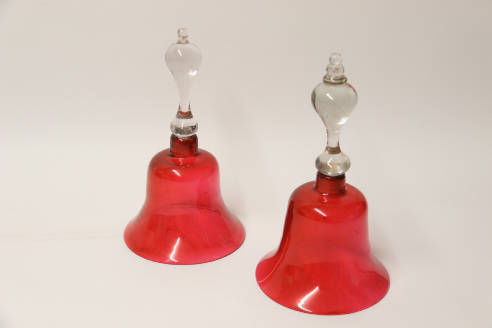 A pair of Victorian hand bells crafted from ruby red glass with clear glass baluster handles. View VII