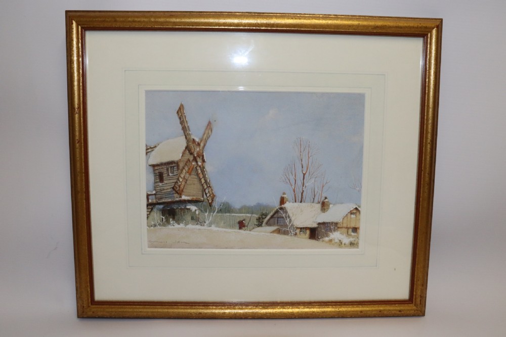 A pair of framed 1930s watercolour paintings by Ernest Uden depicting snowy rural winter scenes featuring a windmill and a timber-framed building. View XI
