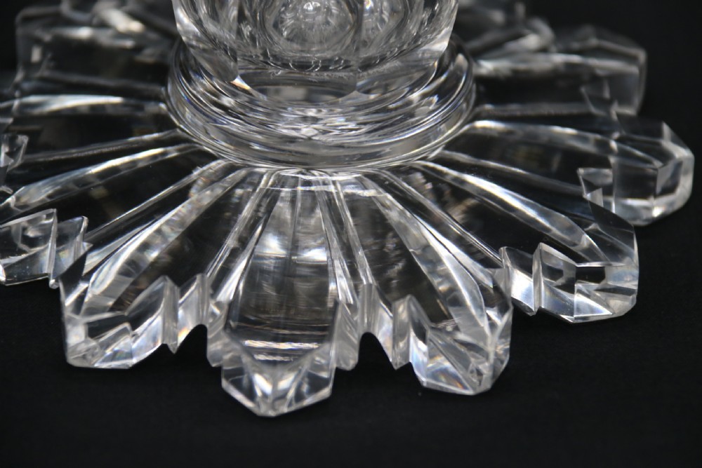 A clear glass commemorative goblet with two loop handles, wheel-engraved with text for the 1911 coronation of King George V and Queen Mary, supported by a faceted stem and starburst base. View VII