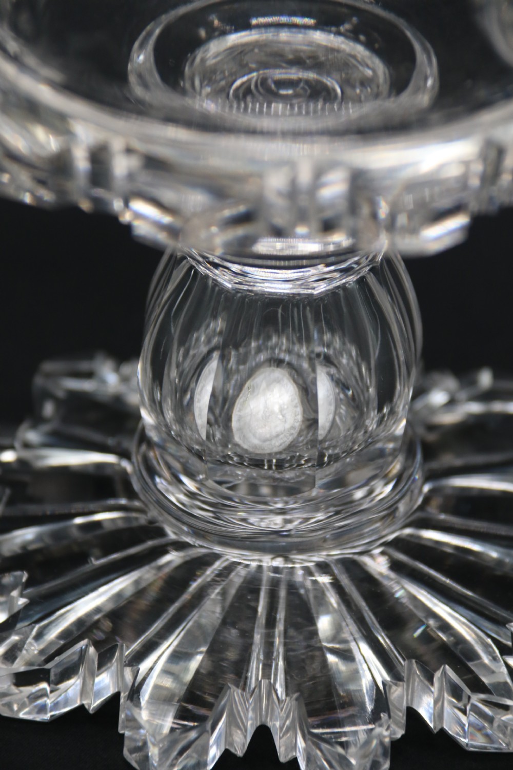 A clear glass commemorative goblet with two loop handles, wheel-engraved with text for the 1911 coronation of King George V and Queen Mary, supported by a faceted stem and starburst base. View VIII