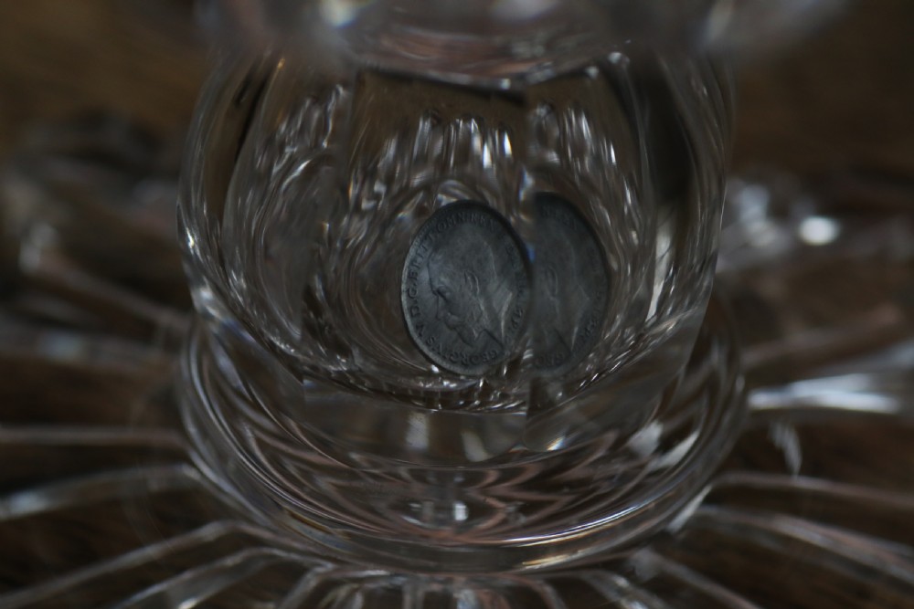 A clear glass commemorative goblet with two loop handles, wheel-engraved with text for the 1911 coronation of King George V and Queen Mary, supported by a faceted stem and starburst base. View XIV