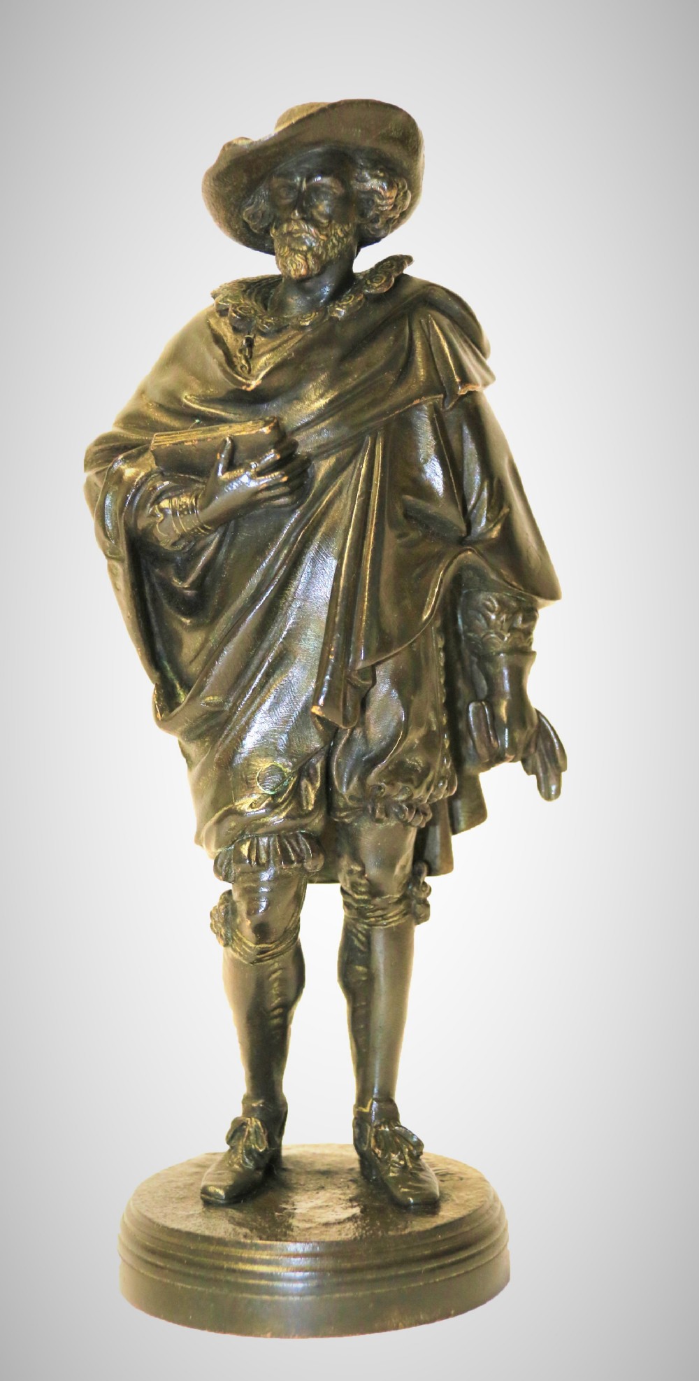 A nineteenth-century patinated bronze sculpture depicting painter Anthony van Dyck in seventeenth-century dress standing on a circular integral base.
