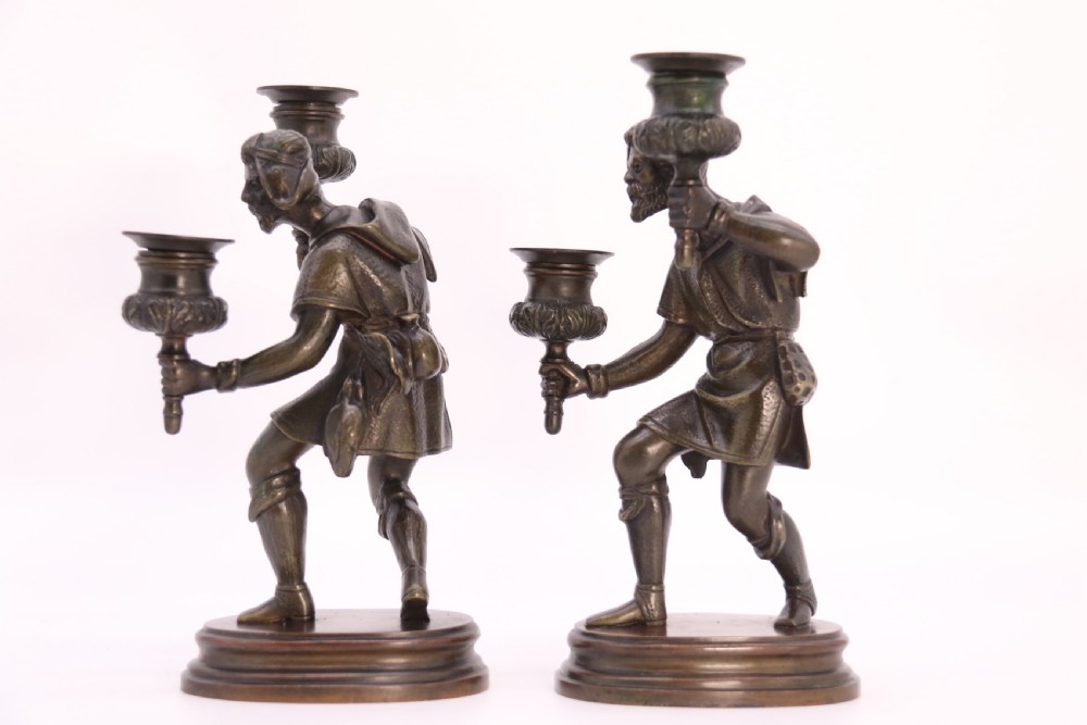 A pair of 19th-century patinated dark bronze double candlesticks featuring sculpted male figures standing on oval bases and holding two sconces each. View VI