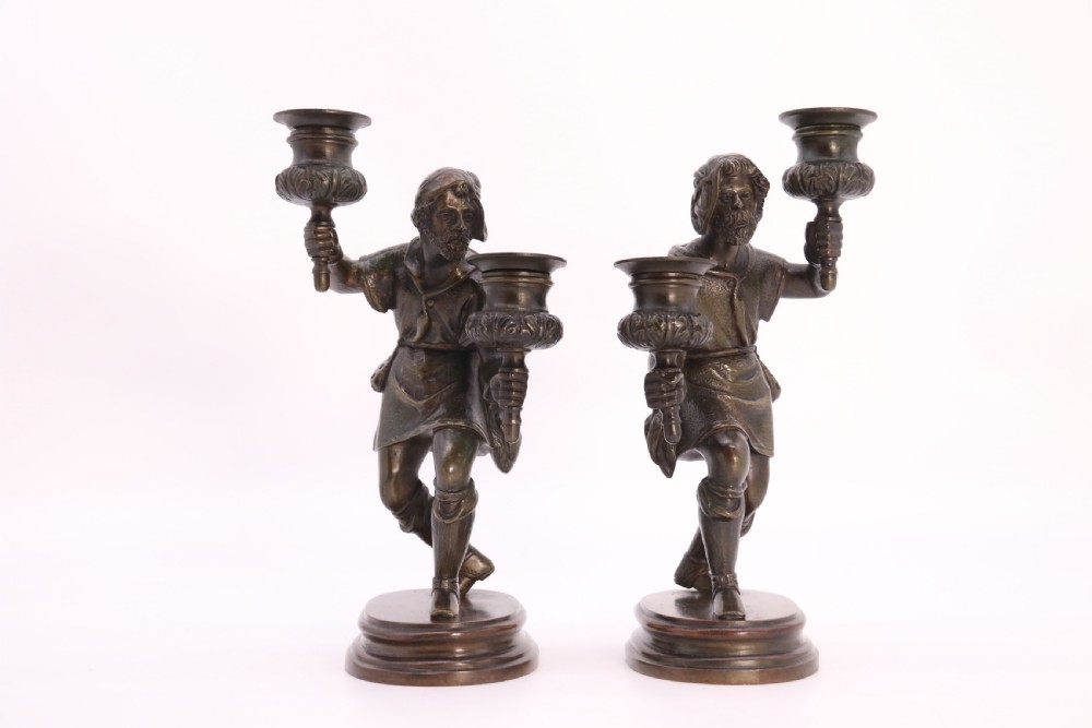 A pair of 19th-century patinated dark bronze double candlesticks featuring sculpted male figures standing on oval bases and holding two sconces each. View VIII