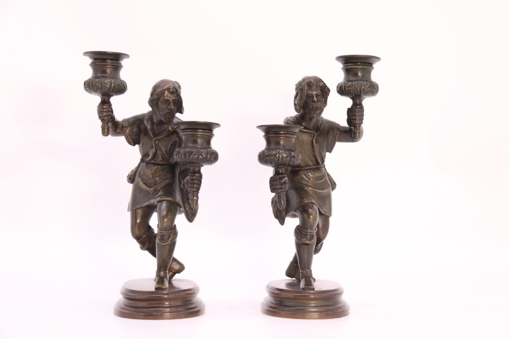 A pair of 19th-century patinated dark bronze double candlesticks featuring sculpted male figures standing on oval bases and holding two sconces each. View XI