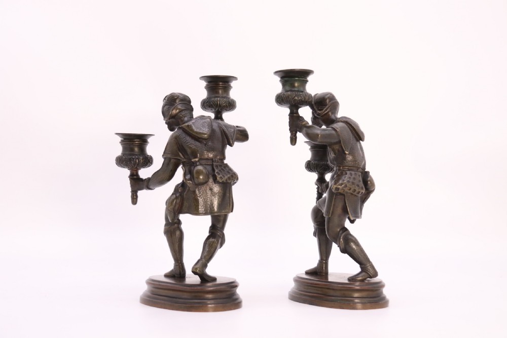 A pair of 19th-century patinated dark bronze double candlesticks featuring sculpted male figures standing on oval bases and holding two sconces each. View XIII