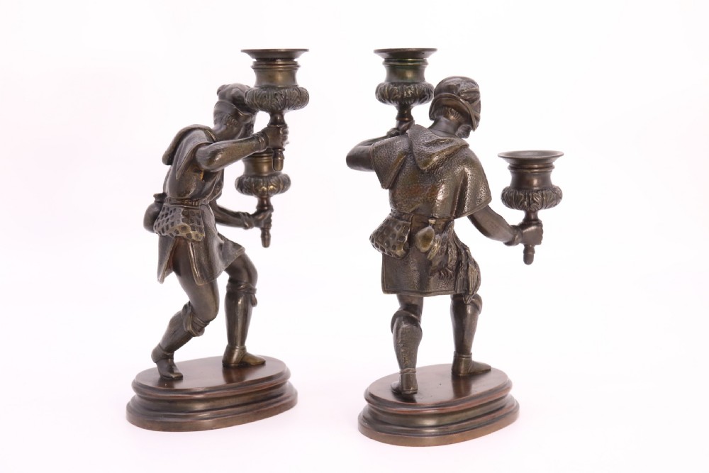 A pair of 19th-century patinated dark bronze double candlesticks featuring sculpted male figures standing on oval bases and holding two sconces each. View XV