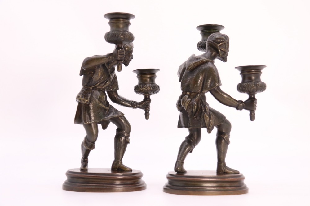 A pair of 19th-century patinated dark bronze double candlesticks featuring sculpted male figures standing on oval bases and holding two sconces each. View XVI