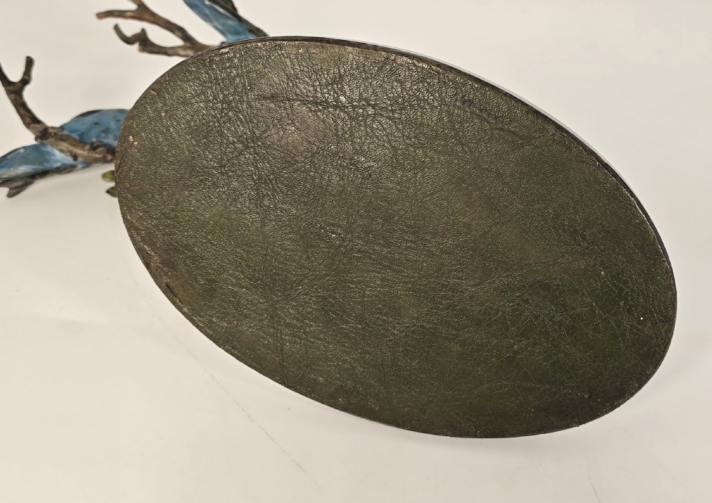 A cold painted bronze sculpture depicting three blue budgerigars perched on a branch mounted on an oval dark marble base. View XV