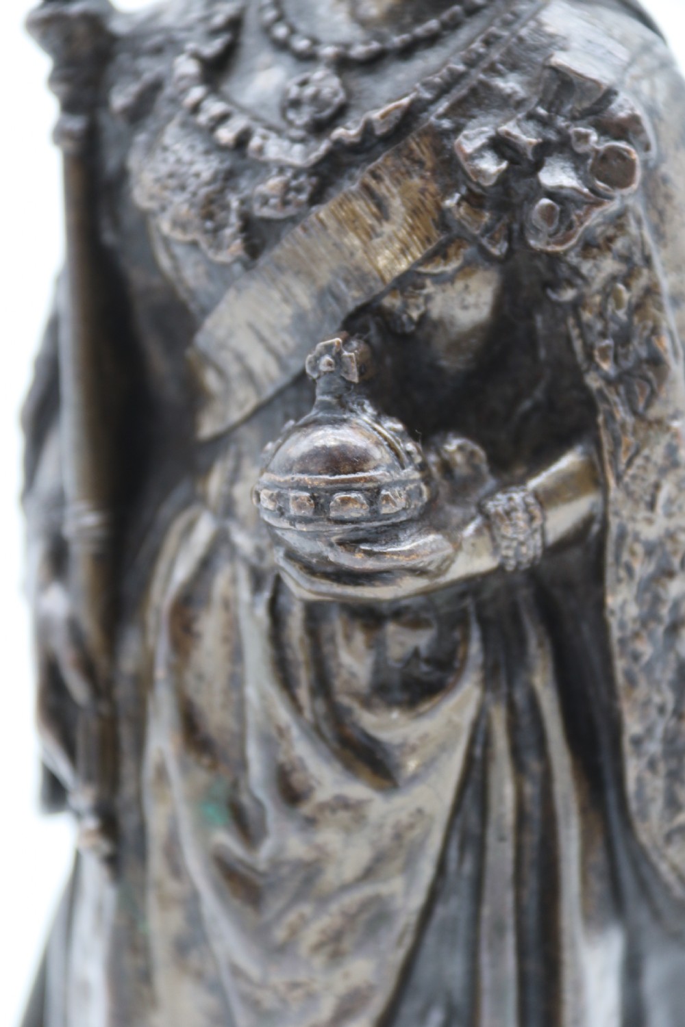 A dark patinated bronze statuette depicting Queen Victoria standing in full ceremonial robes, wearing a crown and holding a sceptre and orb. View VI