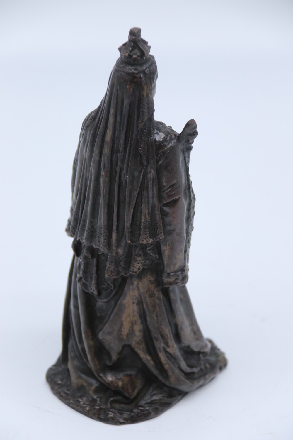 A dark patinated bronze statuette depicting Queen Victoria standing in full ceremonial robes, wearing a crown and holding a sceptre and orb. View IX
