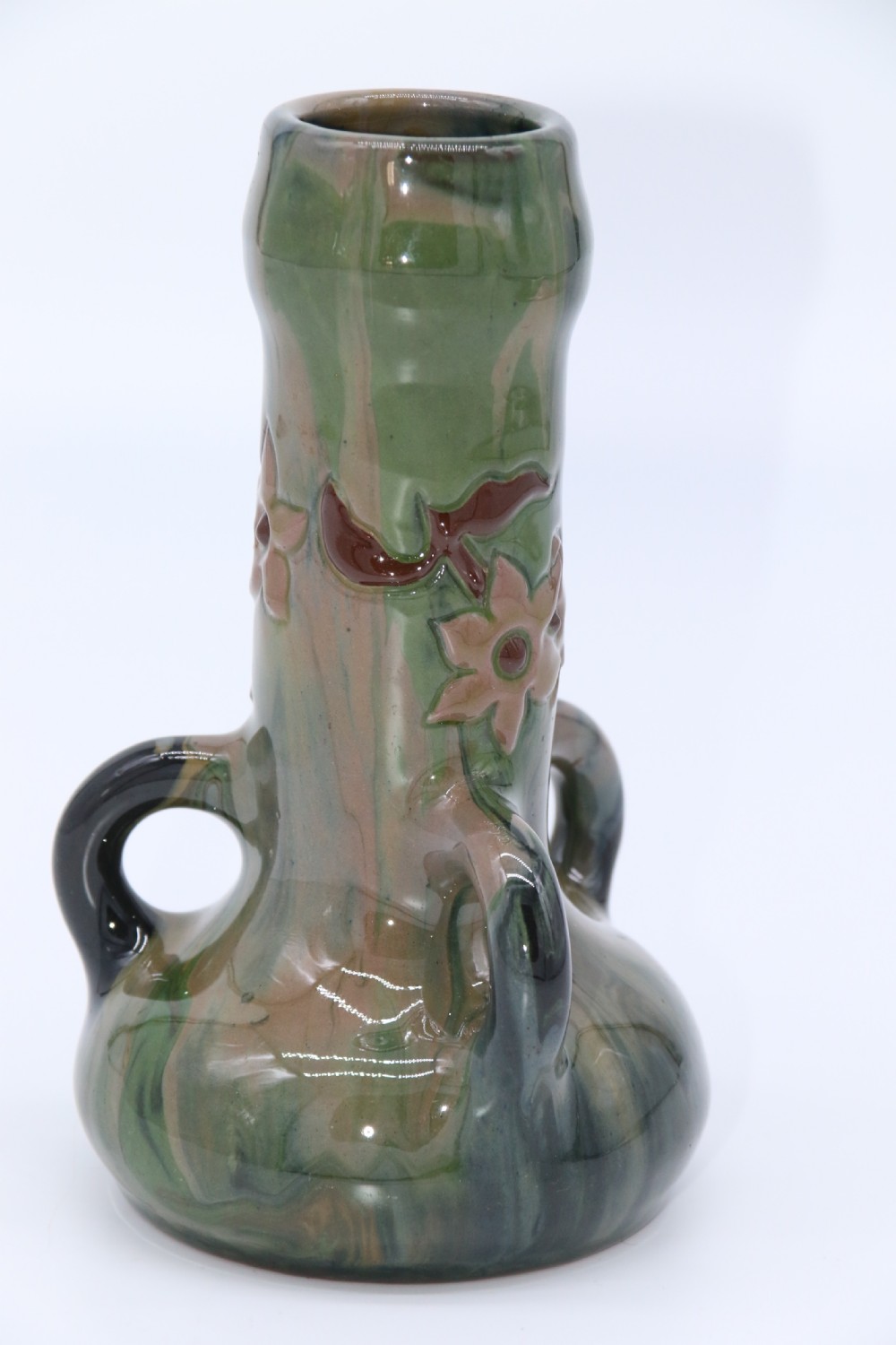 A green and brown glazed earthenware ceramic vase featuring three handles and raised slipware floral decoration. View III