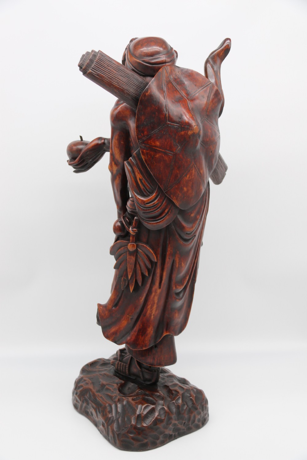 A late 19th-century Japanese Meiji period carved hardwood okimono depicting a standing male figure with a staff, scroll, and fruit on a textured base. View VII