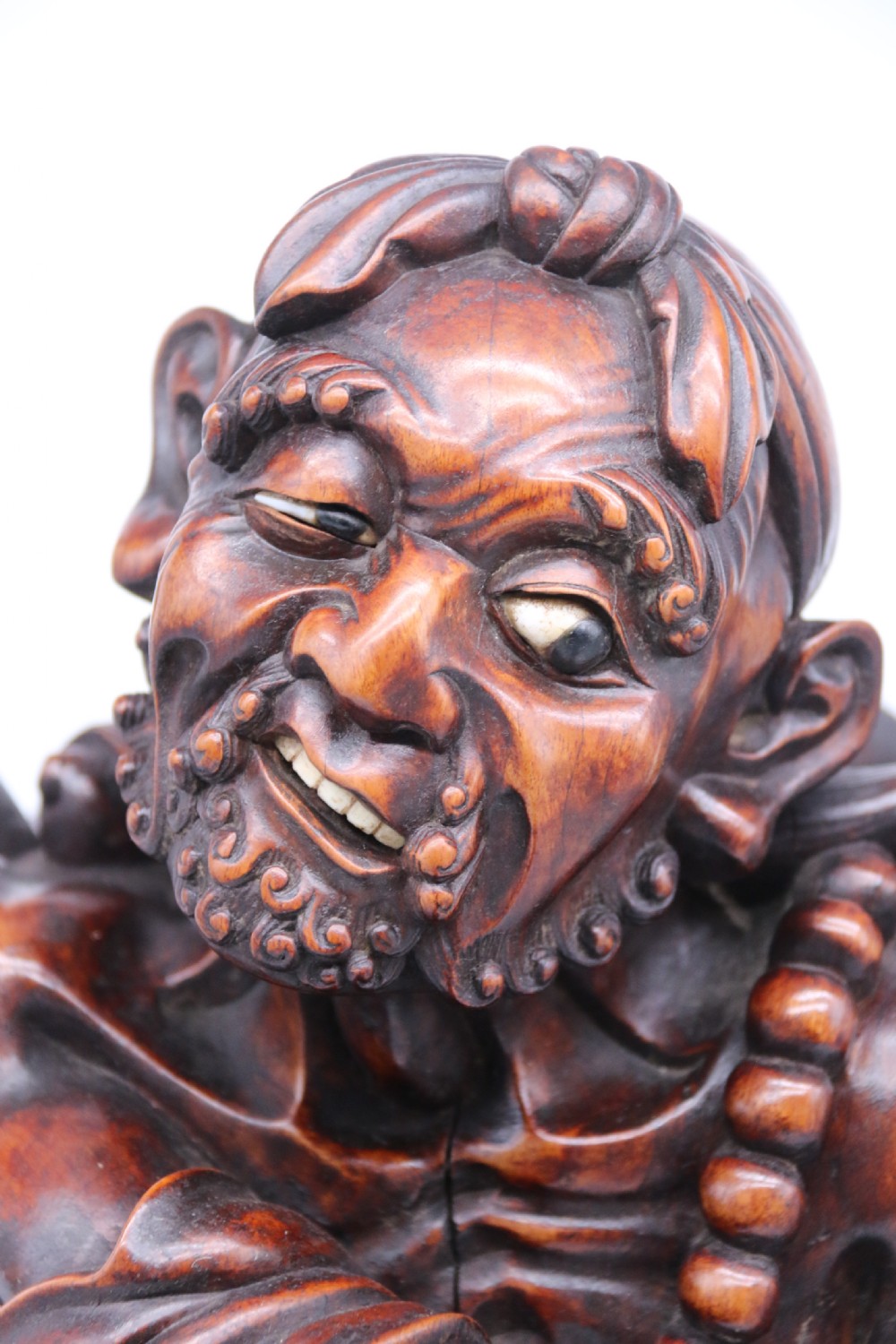 A late 19th-century Japanese Meiji period carved hardwood okimono depicting a standing male figure with a staff, scroll, and fruit on a textured base. View XI
