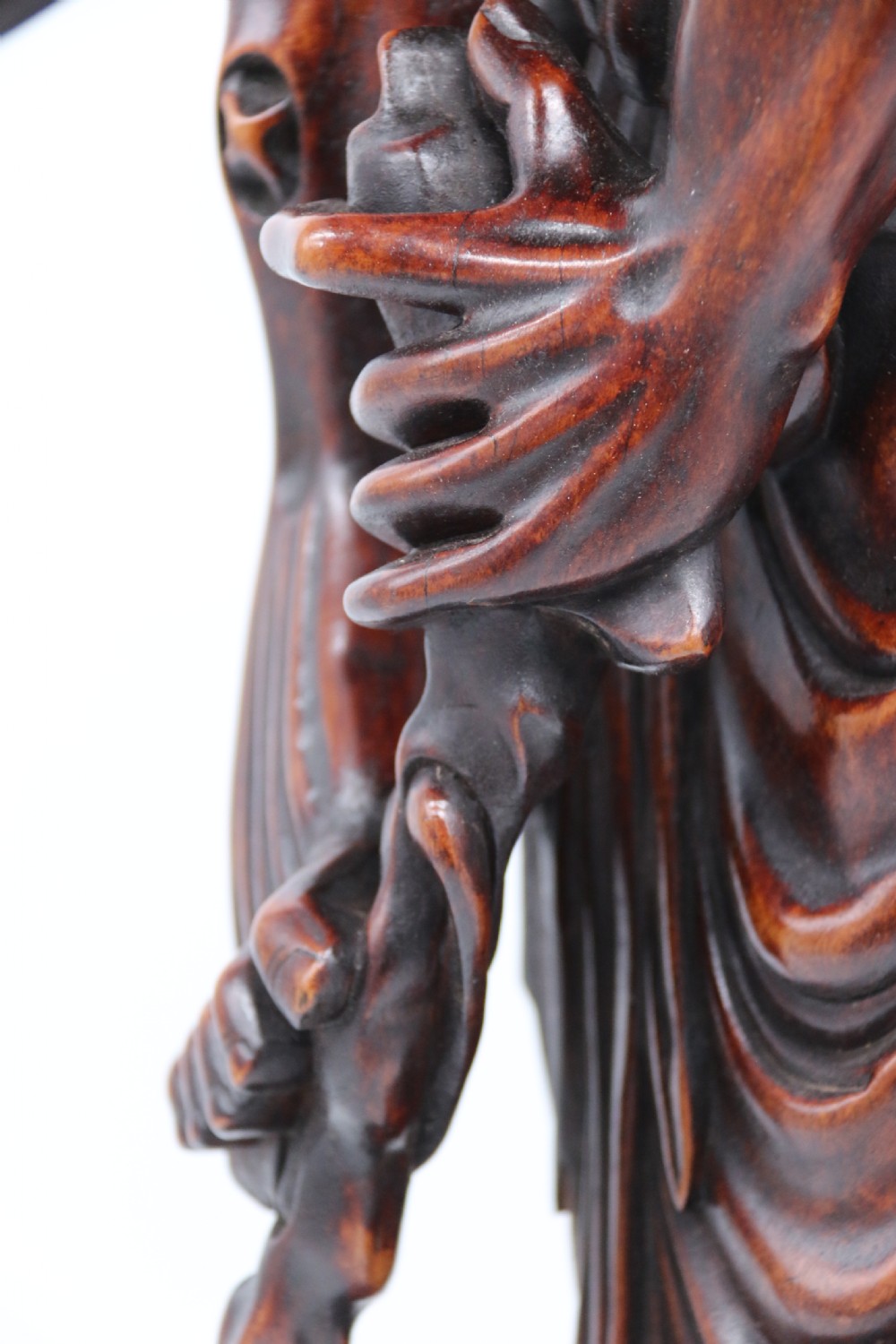 A late 19th-century Japanese Meiji period carved hardwood okimono depicting a standing male figure with a staff, scroll, and fruit on a textured base. View XIV