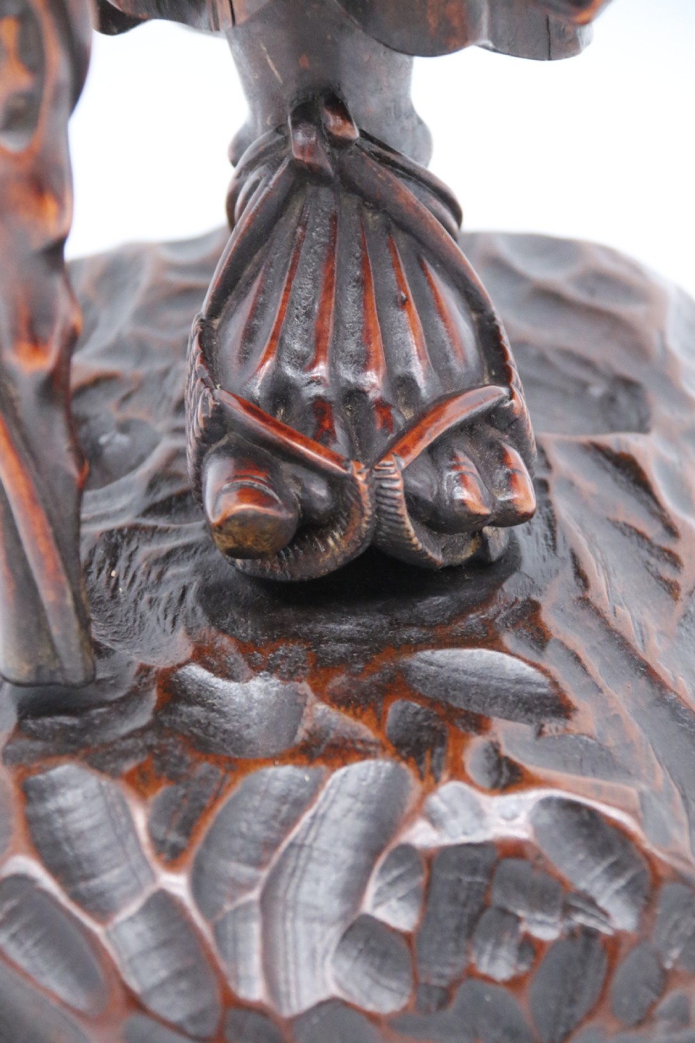 A late 19th-century Japanese Meiji period carved hardwood okimono depicting a standing male figure with a staff, scroll, and fruit on a textured base. View XVIII