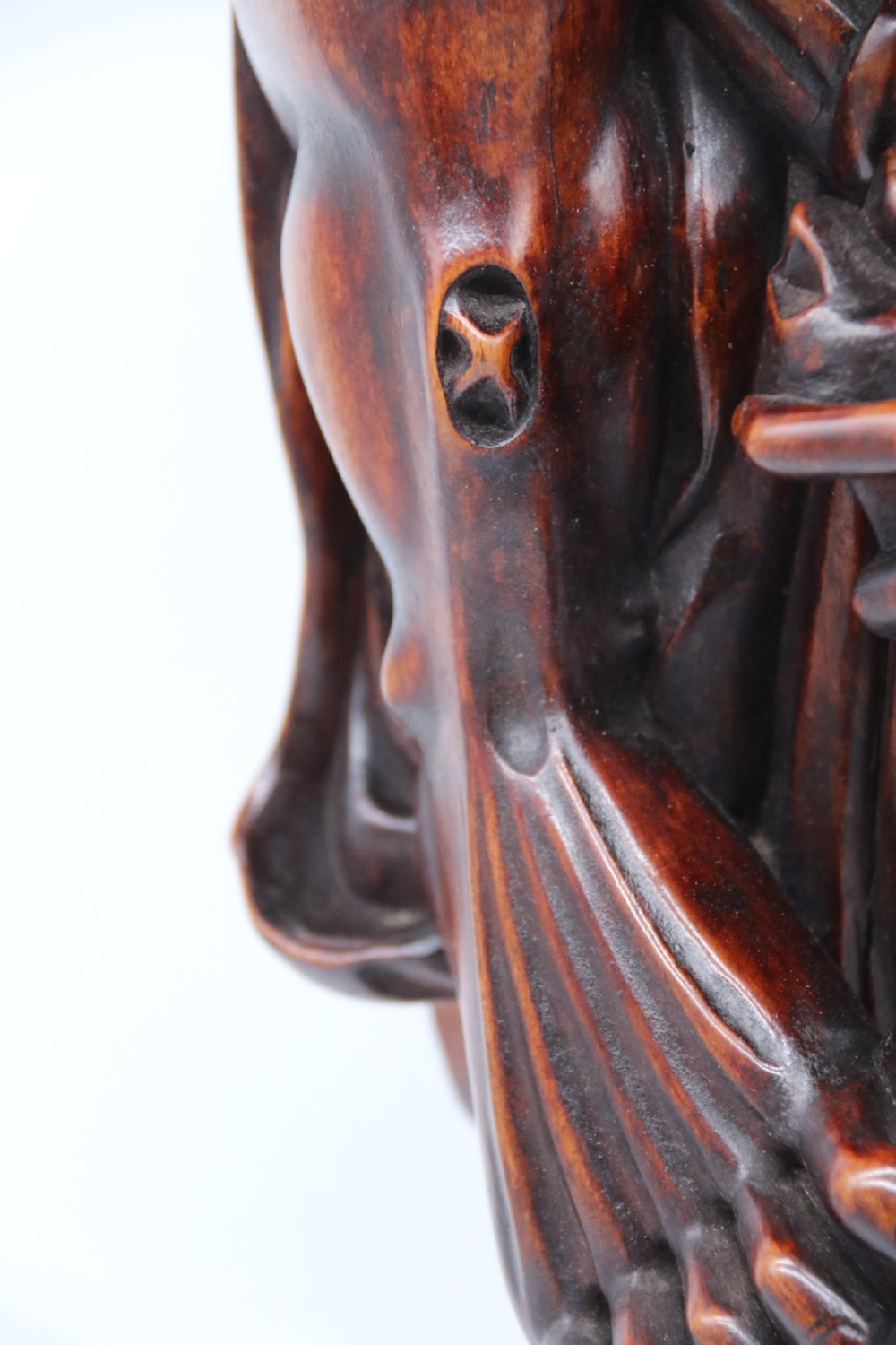 A late 19th-century Japanese Meiji period carved hardwood okimono depicting a standing male figure with a staff, scroll, and fruit on a textured base. View XIX