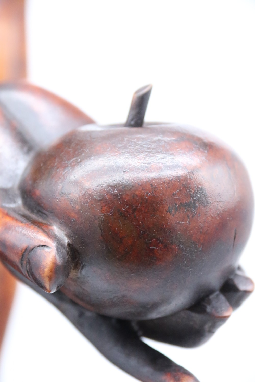 A late 19th-century Japanese Meiji period carved hardwood okimono depicting a standing male figure with a staff, scroll, and fruit on a textured base. View XXIV