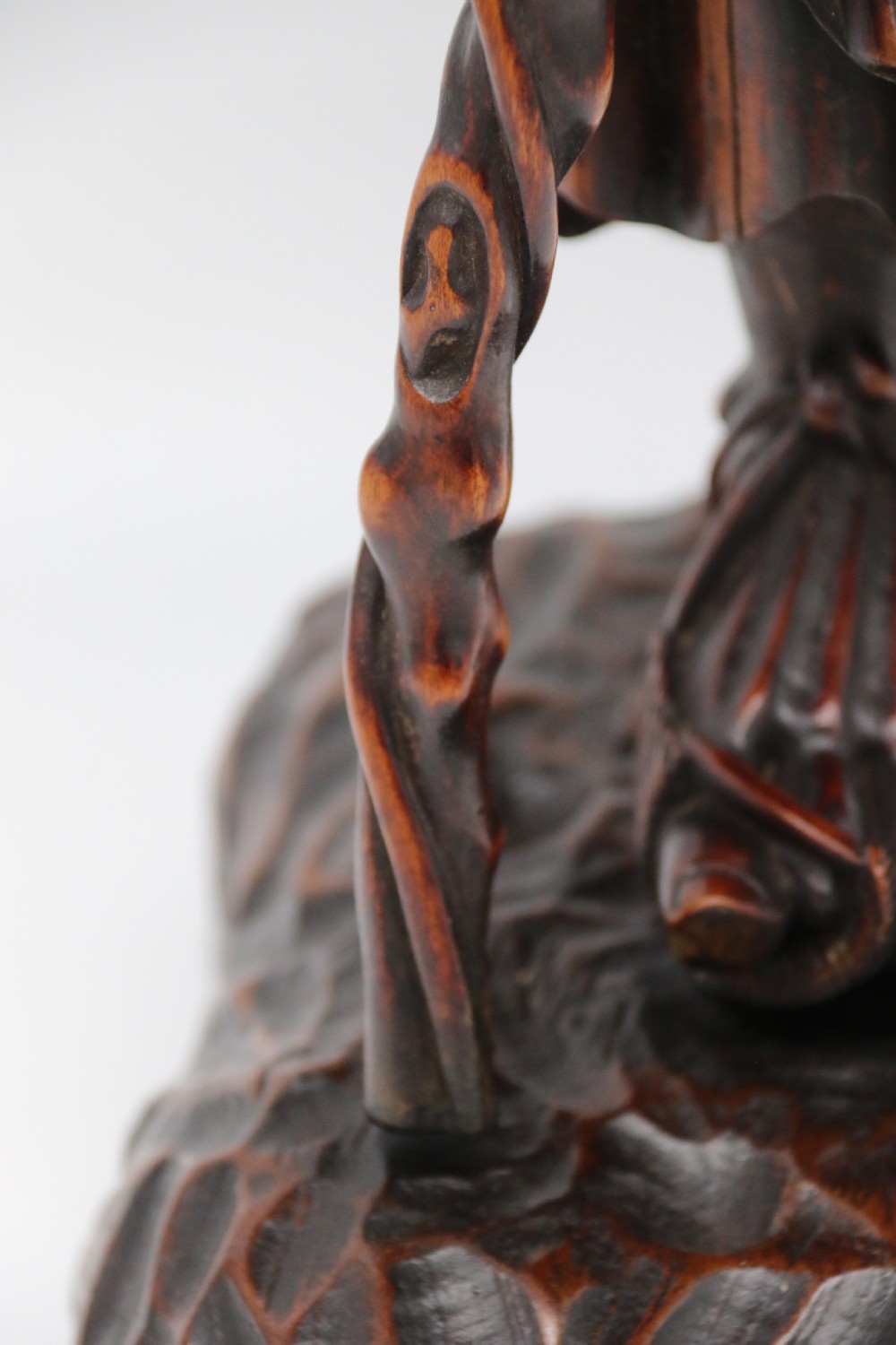A late 19th-century Japanese Meiji period carved hardwood okimono depicting a standing male figure with a staff, scroll, and fruit on a textured base. View XXV